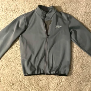 Grå fleecetröja från Oscar Jacobson - Snygg grå fleece från Oscar Jacobson med dragkedja och hög krage. Perfekt för en stilren look. Perfekt inför våren och sommaren. Jackan har långa ärmar och en enkel design som passar till mycket.