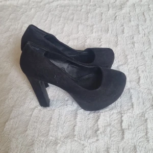Svarta pumps - Snygga svarta pumps från Divided med hög klack och rundad tå. I fint skick.