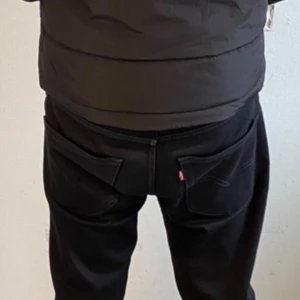 Svarta Levis 502 jeans - Snygga svarta Levis 502 jeans med klassisk design. De har en rak passform och är tillverkade i slitstarkt denim. Perfekta för en stilren look.