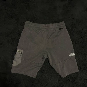 The North Face shorts - Snygga grå shorts från The North Face med praktiska fickor och en bekväm passform. Tillverkade i ett mjukt och slitstarkt material.