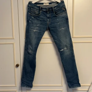Replay Jeans - Tja! Säljer dessa populära Replay jeansen, i modell Anbass slim fit med slitningar. Storlek (W31) (L32). Köpta sommaren 2024 på jeansbolaget för 1799kr kvitto finns, näst in till nya då dom knappt använda, vid frågor är det bara att höra av sig! Priset kan diskuteras vid snabb affär skicket är som nya!!
