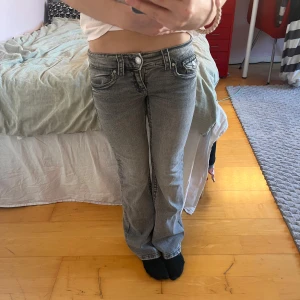 Grå jeans från Gina Tricot, använt 2 gånger nästan helt nytt skick❣️ pris kan diskuteras!! - Snygga grå jeans från Gina Tricot med låg midja och bootcut-stil. De har en klassisk femficksdesign och stängs med dragkedja och knapp. Perfekta för en avslappnad look.