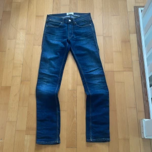 Mörkblå jeans från Acne Studios - Snygga mörkblå jeans från Acne studios.Jeansen har subtila slitningar och kontrastsömmar, vilket ger en stilren och modern look. Perfekta för dig som gillar en tidlös och clean stil.