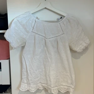 Vit broderad blus med spetsdetaljer - Superfin vit blus med broderade blommor och spetsdetaljer. 