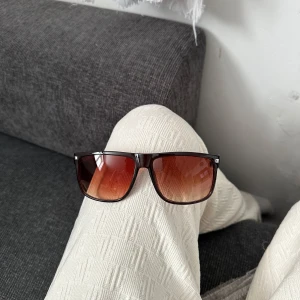Rayban boyfriend liknande - Snygga solglasögon med svart, fyrkantig båge och bruna tonade glas. Klassisk modell som ger en cool vibe och passar perfekt till sommaren. Bågarna är i plast och har en stilren look med diskreta silvriga detaljer vid gångjärnen.