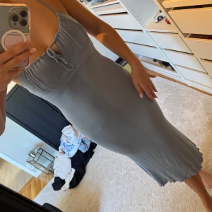 Baby blå ribbad klänning med knyt - Baby blå ribbad klänning med smala axelband och knyt framtill vid bysten. 