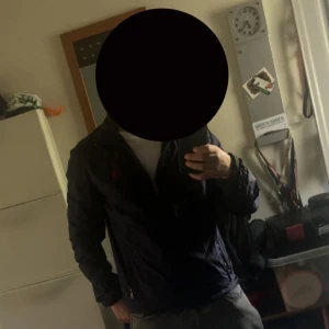 Mörkblå windbreaker från Polo Ralph Lauren - Säljer en stilren mörkblå Windbreaker från Polo Ralph Lauren med röd broderad logotyp på bröstet. Jackan har dragkedja framtill och två fickor med dragkedjor. Perfekt för en casual look.