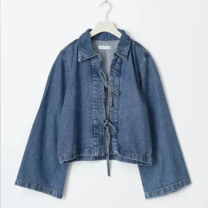 Blå jeansjacka med snörning - Trendig blå jeansjacka från Gina tricot med vida ärmar. Jackan har snygga knytband framtill
