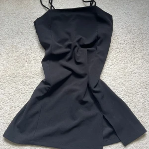 Svart kort klänning med slits - Snygg svart kort klänning med en snygg slits. Skriv vid frågor😊 Går att diskutera pris!