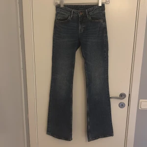 Mörkblå bootcut jeans - Snygga mörkblå jeans med bootcut-modell och klassisk femficksdesign. Jeansen har en lätt tvättad. Perfekta för dig som gillar en Sthlmstil och vill ha ett par jeans som sticker ut lite extra.