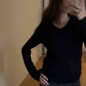 Svart v-ringad tröja från Vila - Jättesimpel och söt svart tröja från Vila med v-ringad hals och lång ärm. Passar jättefint till jeans eller kjol! Tröjan har en litet hål på ena ärmen men är annars i bra skick. Storlek: S💋💋