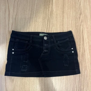 Svart mini kjol - Väldigt kort svart minikjol med unika detaljer. Har ej använt och den är köpt second hand för flera år sedan.