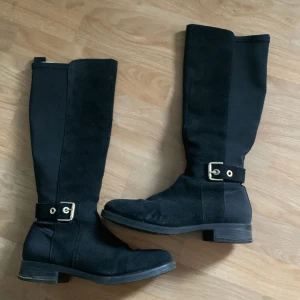 Svarta höga boots från Tommy Hilfiger - Snygga svarta boots från Tommy Hilfiger i mocka och textil med guldfärgade detaljer. Jätte fina och bekväma
