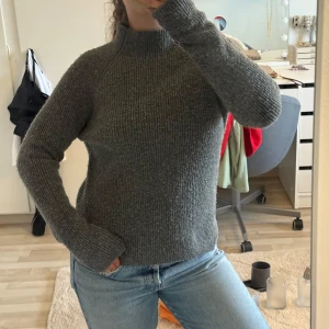 Stickad tröja - Mysig grå stickad tröja med hög hals och långa ärmar och slit i sidan.