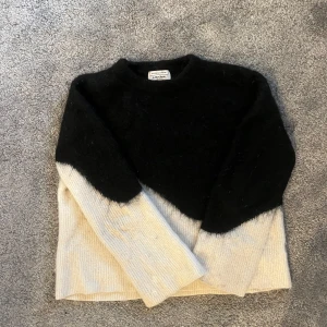 Svart och vit stickad tröja & Other Stories - Säljer en snygg stickad tröja från & Other Stories med cool diagonal färgblock i svart och vit. Tröjan har långärmad passform och är gjord i ett mjukt, fluffigt material som känns riktigt mysig. Perfekt till höst och vinter när du vill vara både varm och stilren. Använd några antal gånger💕
