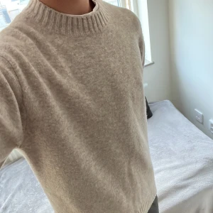Beige stickad tröja - Mysig beige stickad tröja från Uniqlo i storlek XS men skulle passar även S. Perfekt nu till hösten oxh passar till allt. Enkel och stilren design som funkar året runt. Modellen är 180cm