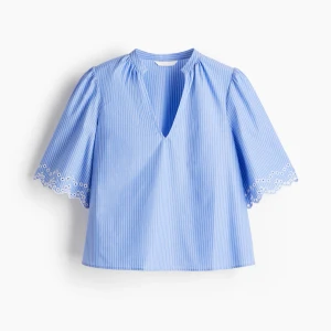 Topp H&M - Supersöt blus i ljusblått och vitt med tunna ränder, v-ringning och vida korta ärmar med broderad spetskant. Perfekt för en fräsch och somrig look. Luftig passform och mjukt bomullsmaterial.