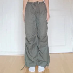 Gröna cargopants från FB Sister - Gröna cargopants från FB Sister med bred passform och dragsko i midjan och vid benslut. Byxorna har flera fickor på sidorna och baktill, och är tillverkade i ett skönt bomullstyg. Passar både xs och s. Väldigt lite använda.