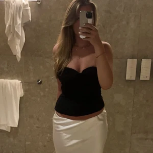 Svart axelbandslös korsett-topp - Säljer en svart korsett-topp med axelbandslös bandeau. Så så snygg och perfekt till en utekväll eller bara till en middag. As snygg och helt slutsåld från Zara. Köptes på Zara för 2 år sedan💌