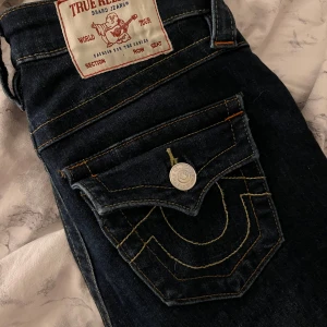 True Religion Becca Bootcut Jeans - Super Snygga mörkblå jeans från True Religion,inga täcken på användning.Använda typ 3 gånger.De passar mig perfekt som är 167 cm.modell Becca Mid Rise Bootcut.Säljer de för att de inte längre kommer till användning💙nypris 1299kr