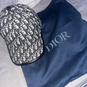 Dior keps med monogrammönster - Dior keps i nytt skick. Passar perfekt till festliga eller speciella tillfällen då den skiljer sig från andra kepsar. Lyxig och fångar många blickar 