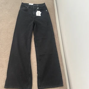 Svarta wide leg jeans Tower Wide 27/32 - Snygga svarta jeans från Bik Bok. De är högmidjade och breda ben för en riktigt trendig siluett. De är splittrans nya o har aldrig använts, kom helt enkelt aldrig till använda. Perfekta för dig som gillar en loose och elegant look. Ordinare pris 599kr. 