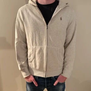 Ralph Lauren kofta - Snygg grå hoodie från Ralph Lauren med dragkedja. Bra skick! Modellen är 186 cm lång! 