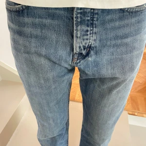 Blå raka jeans från Ralph Lauren - Snygga blå jeans från Ralph Lauren med klassisk femficksdesign och RL-broderi i rött på myntfickan. Jeansen har rak passform och normal midja. Storlek 32:32