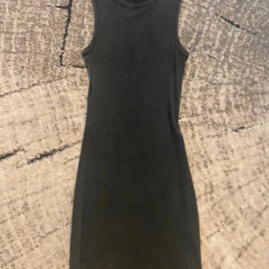 Svart ärmlös klänning från Divided - Skick: Bra Storlek: Xs Material: bomull Märke: H&M                                                        snygg svart ribbad klänning från Divided i storlek XXS. Modellen är ärmlös med rund hals och har en tight passform som framhäver figuren. Perfekt för dig som gillar minimalistisk stil och vill ha en enkel men trendig look.