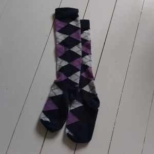 Rutiga lila och blå ridstrumpor - Snygga knälånga ridstrumpor med rutigt mönster i lila, vitt och marinblått.
