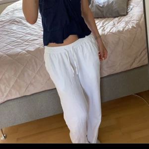Vita linnebyxor  från 157 - Säljer ett par vita linnebyxor från 157 i storlek XS. Byxorna har en relaxed passform med resår och dragsko i midjan samt raka ben. Perfekta för varma dagar och riktigt sköna att ha på sig.