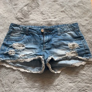 Lågmidjade jeans shorts - Lågmidjade jeans shorts med spetsdetalj nertill. Midjemått 40 cm💞💞