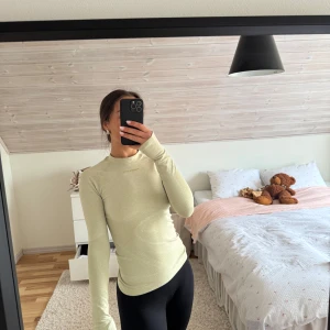 Ljusgrön  långärmad träningströja - Ljusgrön långärmad träningströja med tight passform. Tröjan har diskret mönster i tyget och är tillverkad i ett stretchigt syntetmaterial som andas. Perfekt för träning eller som baslager. 