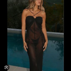 Svart långklänning Portofino Slip Dress från Avora - Säljer en svart långklänning från Avora, aldrig använd , modellen Portofino Slip Dress. Klänningen är axelbandslös med tunna band som korsas framtill och har en transparent, flowy look. Nypris:1600 mitt pris:500