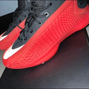 Svarta och röda sneakers med unik sula basket skor 39 ae1 - Säljer ett par sneakers med svart ovandel och röd, texturerad sula. Skorna har snörning och en sportig design med rund tå och platt sula. Perfekta för dig som gillar att sticka ut med dina skor. Basket skor storlek 39 använda ungefär 5 gången kan prutas 