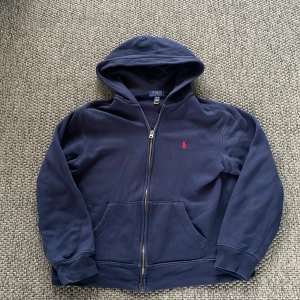  Polo Ralph Lauren tröja - Säljer en mörkblå hoodie från Polo Ralph Lauren med dragkedja och huva. Perfekt nu inför sommaren☀️säljer för att den e för liten.