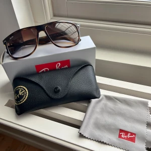 Ray Ban Boyfriend  - Ray Ban Boyfriend storlek 60. Köpta under sommaren 2024 från synoptik men är väldigt sparsamt använda och är i princip nysick. Allting på bilderna ingår vid köp, bara höra av dig vid frågor eller funderingar!           Kan mötas i Stockholm eller frakta vart som helst inom Sverige. 