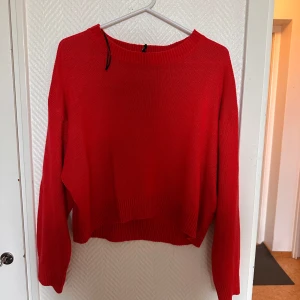 Röd stickad tröja från Divided - Säljer en röd stickad tröja från Divided. Tröjan har en rund halsringning, lång ärm och är något croppad i modellen. Perfekt för att addera färg till din garderob!