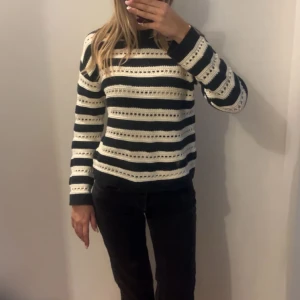 Randig stickad tröja i svart och vitt - Säljer en stickad tröja med svarta och vita ränder. Tröjan har lång ärm och rund halsringning. Perfekt för dig som gillar klassiska mönster och vill ha något mysigt till garderoben.