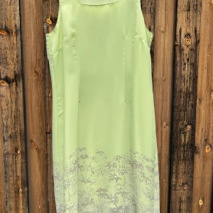 Ljusgrön ärmlös klänning med blommigt mönster -FRANSA - Säljer en ljusgrön ärmlös klänning med subtilt blommigt mönster nertill. Klänningen har en rak passform och är tillverkad i ett lätt, glansigt material som ger en elegant känsla. Perfekt för sommarens tillfällen!    Från märket Fransa