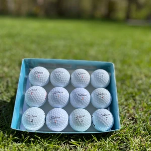 Titleist golfbollar i ask - Säljer en ask med 12 stycken vita golfbollar från Titleist. Perfekt för golfentusiasten som vill ha kvalitetsbollar till nästa runda. Bollarna är i A-klass.