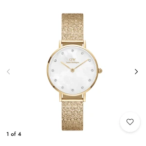 Daniel Wellington Guld Klocka Dam - Snygg klocka från Daniel Wellington med guldigt mesharmband och vit pärlemor-urtavla. Urtavlan har glittriga stenar som index och DW-logga. Inga skador, knappt använd. Nypris 2199kr pris kan diskuteras