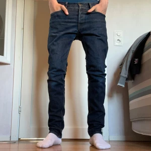 Mörkblå jeansbyxor från Jack's Workwear - Säljer ett par mörkblå jeansbyxor från Jack's Workwear. Klassisk femficksmodell med raka ben och normal passform. Storlek 30 32