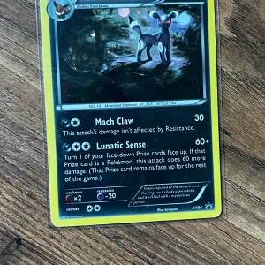 Umbreon kort - Samlarobjekt! Ett Pokémonkort med Umbreon, en populär och mystisk Pokémon. Kortet har attacker som Mach Claw och Lunatic Sense. Perfekt för dig som gillar Pokémon, samlar på kort eller vill ha något unikt i din samling.