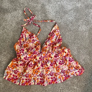  somrig linnetopp - Säljer en färgglad blommig linnetopp med djup v-ringning och knytband i nacken och öppen rygg. Ej andvänd. 🥰