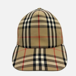 Beige rutig keps från Burberry - Snygg keps från Burberry i klassiskt beige rutigt mönster med svarta, vita och röda linjer. Kepsen har böjd skärm och justerbar passform. Perfekt accessoar för att lyfta din outfit med en lyxig touch och är en perfekt och fin keps till sommaren