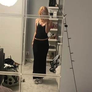 Svart långkjol med slits - Säljer en svart långkjol med slits på sidan. Kjolen har en enkel och stilren design med rak passform och hög midja. Köpt på Ullared. Pris går att diskutera 