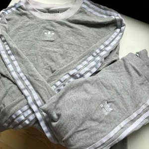 Adidas sett - Sett med tröja och leggings.  Fint skick överlag men det finns ett litet hål på byxorna (se bild)  Tröja storlek 34 Leggings storlek 38 (dom är något mindre i storleken, skulle säga att dom är mer som 36)