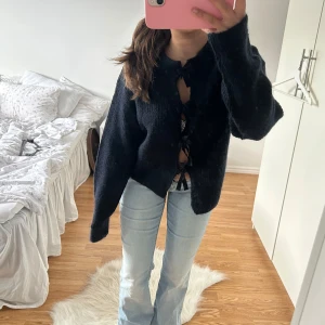 Mörkblå stickad kofta med knyt - Kofta med rosetter från Gina Young, ny med prislapp. Säljer samma i vitt🥰