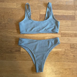 Ljusblå ribbad bikini med sportig topp - Snygg ljusblå bikini med sportig topp och höga trosor. Båda delarna har ribbad struktur som ger en trendig känsla. Perfekt för stranden eller poolen. Materialet känns mjukt och stretchigt för bästa komfort.
